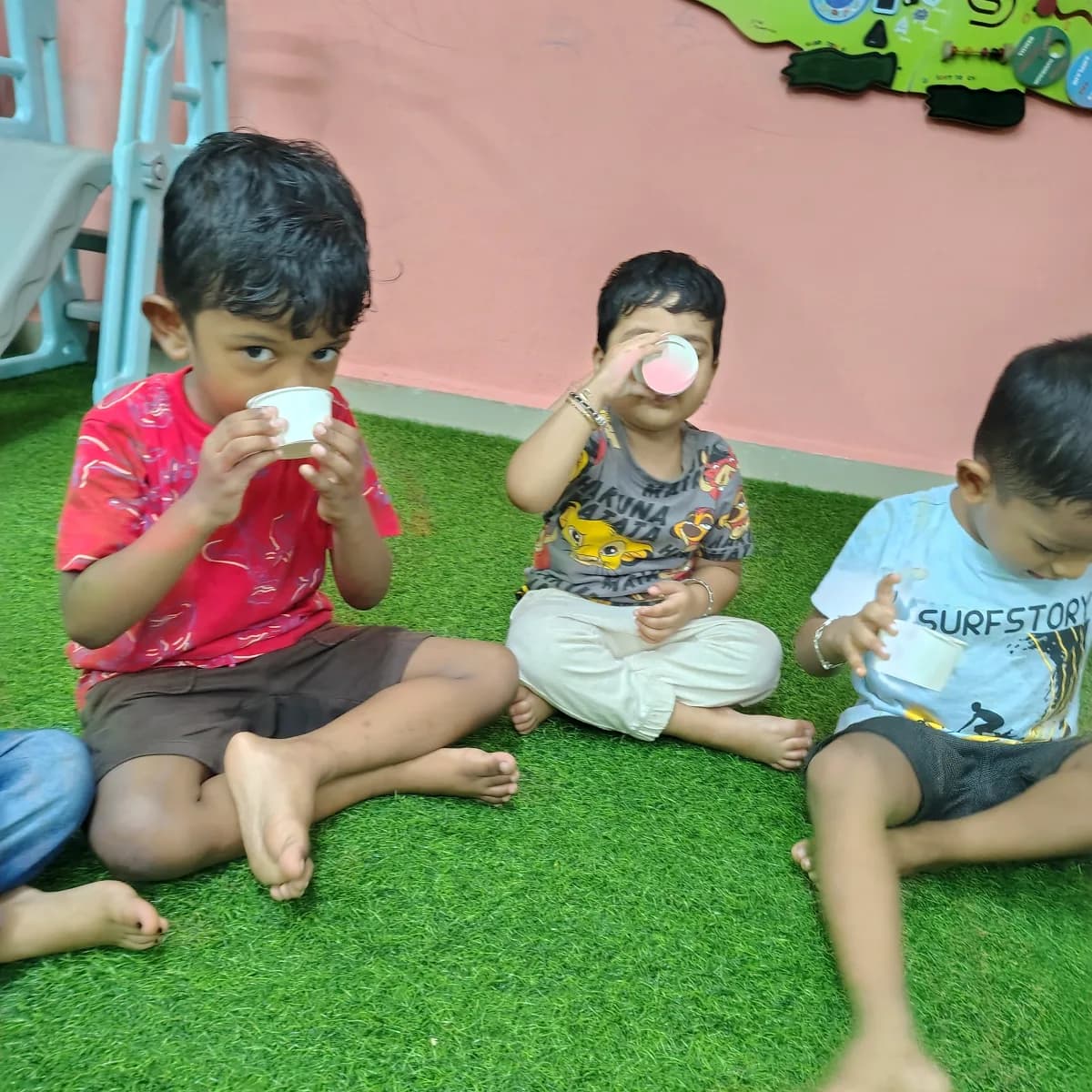 Children sitting together drinking fresh healthy drinks to practice wholesome food habits