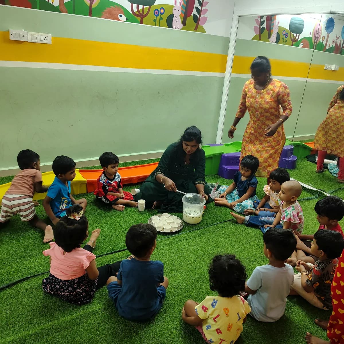 Teacher guiding young children seated in a circle through a fun no-fire cooking activity